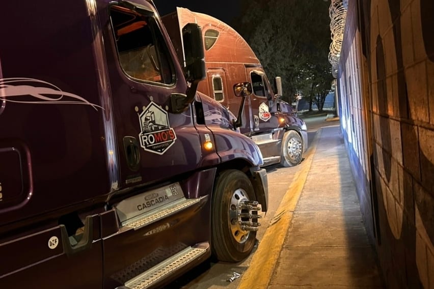Unidades de Romo's Transportes estacionadas durante una operación nocturna, con el emblema de la empresa visible en la puerta del tractocamión.